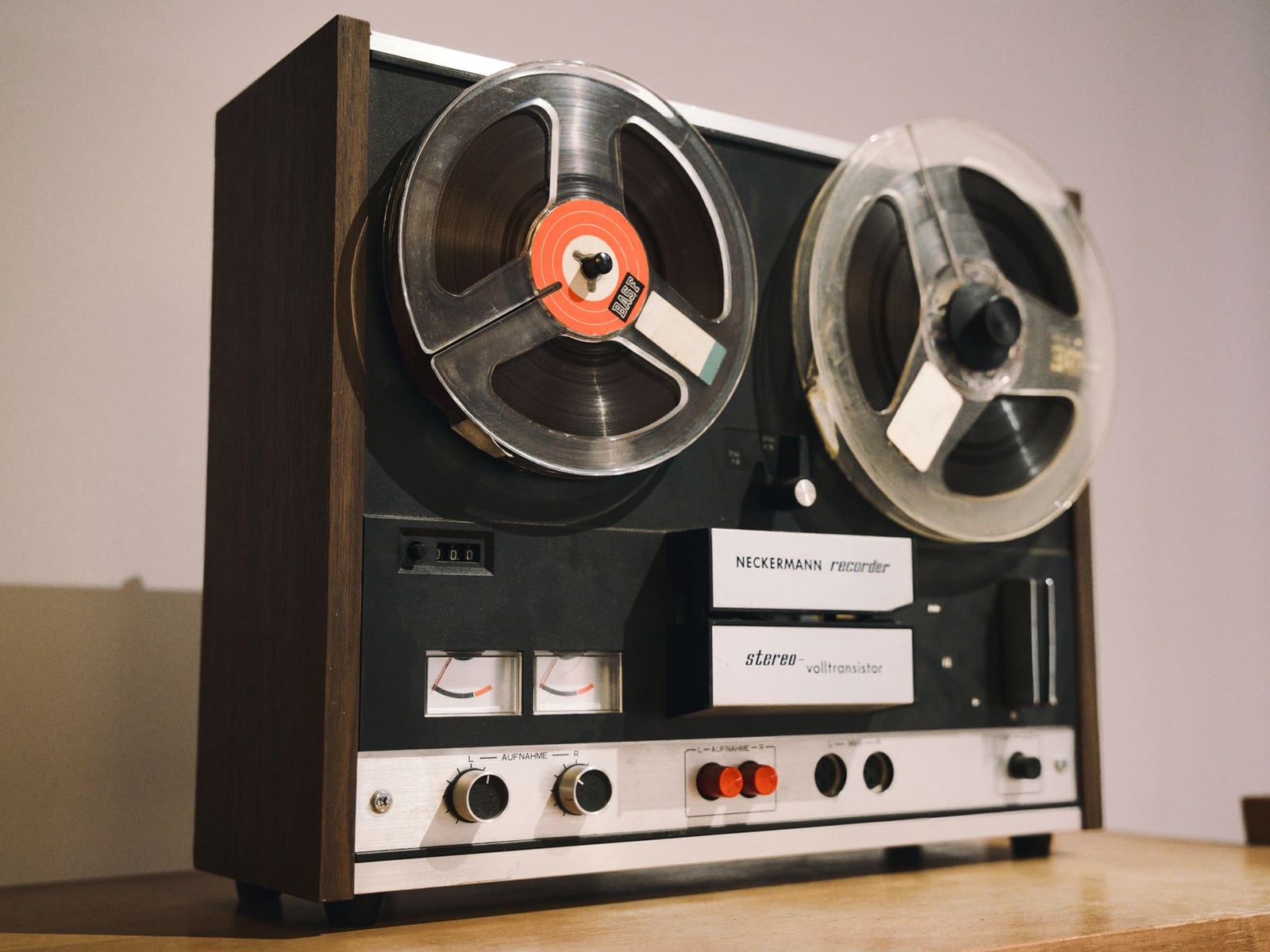 Vintage open-reel tape recorder in operation, focusing on the rotating reels.